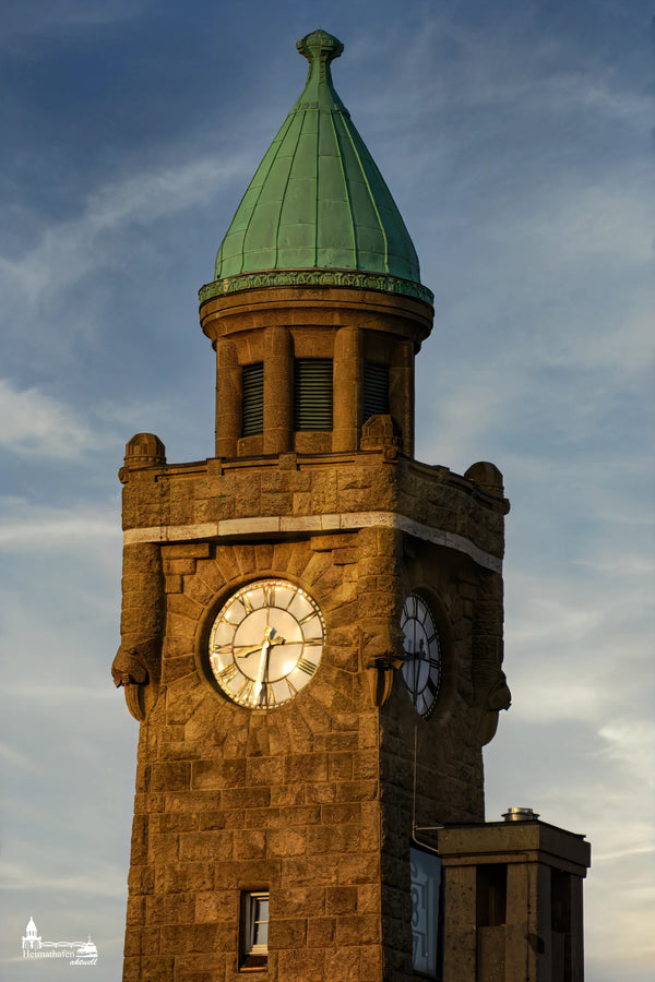 Pegelturm Hamburg Landungsbrücken im goldenen Sonnenlicht mit grünem Kupferdach und Uhrturm.