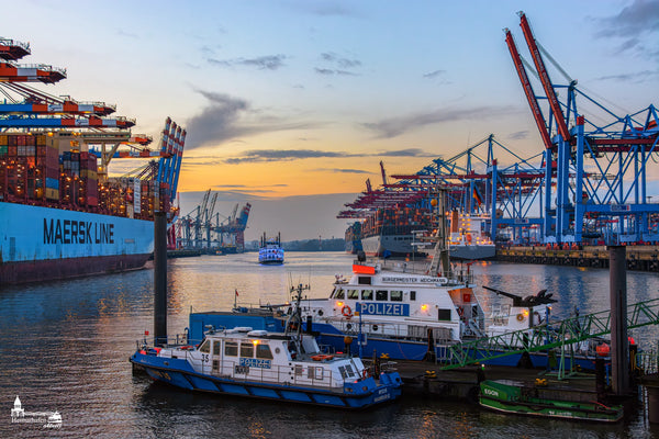 Containerterminal Waltershof mit Polizeibooten Bürgermeister Weichmann und Wasserschutz 35 im Hamburger Hafen bei Sonnenuntergang.