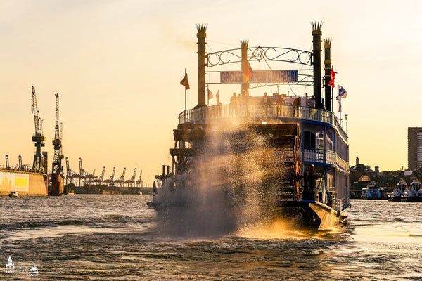 Die Louisiana Star wirbelt Wasser auf bei einer Hafenrundfahrt im goldenen Abendlicht.