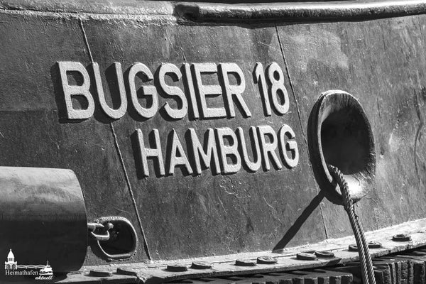 Detailaufnahme des Schriftzugs „BUGSIER 18 HAMBURG“ auf einem Schlepper in Schwarz-Weiß